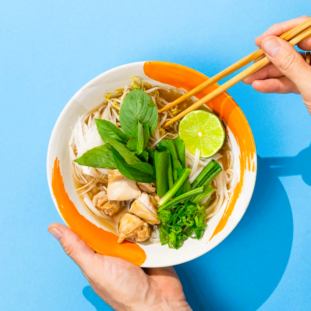 Pho Nudelsuppe mit Huhn, Limette, Sprossen und frischen Kräutern, zubereitet mit J.Kinski Pho Knochenbrühe