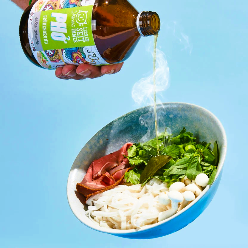 J.Kinski Pho Knochenbrühe wird in eine Pho-Bowl mit Nudeln, Rindfleisch und frischen Kräutern gegossen
